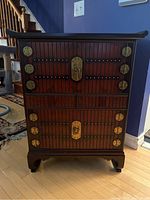 Front view of Asian inspired side table showing two door compartments with brass-tone hardware