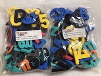 Two plastic bags filled with foam magnetic upper and lower case alphabet letters and numbers in multiple colors.