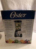 Damaged original box showing Oster Pro 1200 Plus branding and features with image of blender filled with fruit.