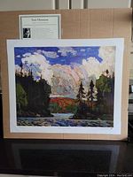 Front view of the large fine art print by Tom Thomson on cardboard backing, showing colorful landscape scene and informational card.