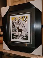 Full view of framed Maud Lewis print with protective white corners on frame.