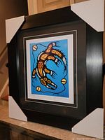 Front view of the professionally framed print with corner protectors showing the full artwork and frame.
