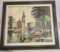 Framed oil painting showing Dutch scene with canal, flower market, boats, buildings, and trees.
