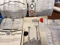 Photo showing multiple vintage certification documents arranged on a table, including documents from the Royal Order of Scotland and Province of Ontario with visible wax seals and embossed stamps.