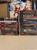 Front spines of the 29 PS2 game cases stacked in two columns.