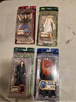 Four Lord of the Rings action figures in original packaging: Eowyn, Galadriel, Arwen, Eye of Sauron