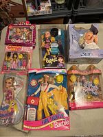 Photo showing all six dolls, including Bratz, Barbie Fire Fighter, Fashion Girl, two small dolls, and Wish Star in boxes with various wear and damage.