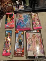 Photo of six dolls in original packaging with visible box damage