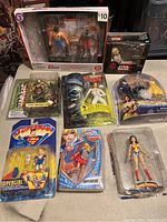 Photo showing the 8 action figures including Superman, two Supergirls, Wonder Woman, Star Wars figures, and Leo Davidson.
