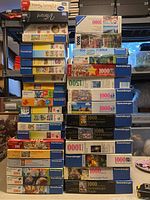 Photo showing an overall stack of Ravensburger puzzles with various piece counts including 1000, 500, 300, and smaller counts.