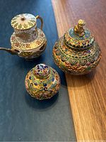 Set of three vintage Chinese cloisonné enamel items on table: large ginger jar with Foo Dog lid, small ginger jar, and dragon motif teapot.