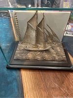 Front view of entire yacht figurine in display case