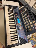 Full view of Yamaha PSR-140 keyboard showing keys, speakers, and music stand on top.