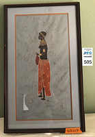 Front view of the framed African art showing the woman in profile with traditional attire and jewelry.