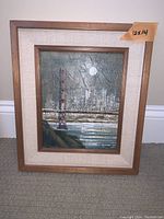 Framed oil painting showing the Golden Gate Bridge with city lights at dusk, wooden frame with fabric matting, 12 x 14 inches total size.
