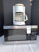 Photo of GE microwave with Stainles steel finish and Mr. Coffee drip coffee maker on top