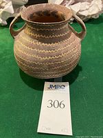 Front view of jar on green surface with lot tag