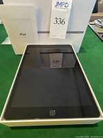 iPad in open box showing front display and original packaging behind