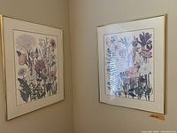 Pair of framed floral prints hanging in a corner, showing the detailed botanical artwork and gold frames.