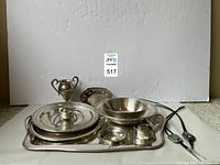 Overall view of rectangular tray with covered dish, bowl, urn, award dish, napkin ring, small dish and bolo ties