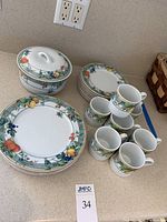 Photo showing the set of Wedgwood Eden porcelain dinnerware including stacked plates, cups, and covered casserole.