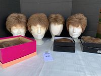 Seven brunette women's wigs shown on mannequin heads and in boxes, highlighting the styles and condition of the lot.