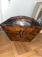 View of the container's exterior showing the hexagonal shape and Chinese characters carved into the wood surface with a dark brown finish.
