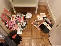 Overview of ballet accessories including sewing kit, fashion tape, foot care products, gloves, hosiery packed on floor.