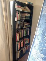 Bookshelf filled with a variety of books of differing genres.