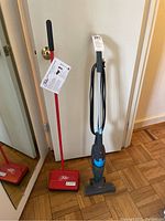 Full view of both carpet sweeper and Bissell vacuum cleaner side by side.
