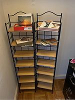 Photo showing two foldable media shelves side by side, containing some media items like albums and books on top shelves.