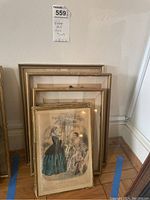 Multiple vintage framed artwork prints stacked against wall, varying sizes from roughly 15x11 to 11x8 inches