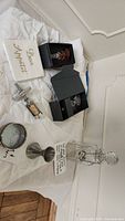 Overview of items including decanter, stoppers, opener, coasters, and napkin laid out on white cloth