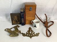 Full lot showing all seven items including the compass box, books, metal bookend, shaving mug, brass pieces, and leather strap