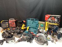 Wide view of all items in the lot showing multiple power tools including cordless drills, saws, and accessory kits.