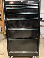 Front view of black Husky Pro rollaway toolbox showing drawers and casters