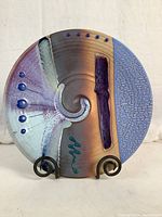 Front view of the ceramic art bowl showing color, texture, and stand