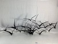 Full front view of entire metal sculpture laid flat against white backdrop