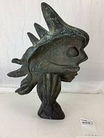 Front view of abstract fish-face sculpture showing profile and fin-like protrusions