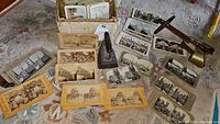 Vintage stereoscopic photo cards arranged on carpet around the stereoscope device
