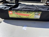 Photo of the carrying case for the padded hammock with a label showing a red hammock on a black metal stand outdoors.