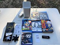 Overview of all items including Xtrfy Bluetooth speaker, PS4 games, anime DVDs, USB drive, and cleaning kit.
