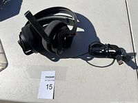 Full view of the black HP Omen gaming headset showing the padded headband, ear cups, microphone, and coiled USB cable on a white surface.