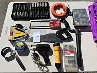 Full overview of the assorted lot showing measuring tape, clamps, saws, hex keys, flashlight, and hand tools.