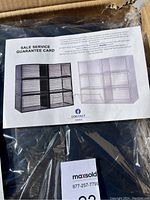 Close up of the sale service guarantee card showing photo of the shoe storage containers to demonstrate appearance and style.