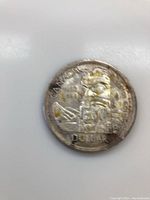 Front side of the 1958 British Columbia Dollar coin showing the totem pole and inscriptions