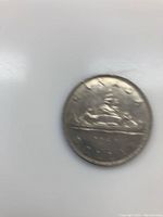 Reverse side of the 1968 silver dollar coin showing the Voyageur design with canoe, paddlers, and date 1968.