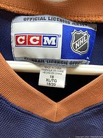 Close-up of official CCM and NHL licensed jersey label showing size 18 (XL/TG 18/20).