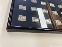 Close-up photo of the framed 1998 Nagano Olympic pins showing the wooden black frame in good condition and pins mounted in neat rows.