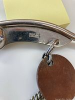 Close-up photo of the polish silver metal whistle with "Made In England" engraving on its side.